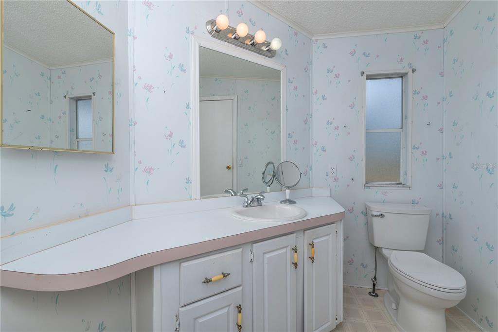 1001 Starkey Road, Unit 767 Largo, FL 33771 - Photo 9 of 41 a bathroom with a sink a toilet and mirror