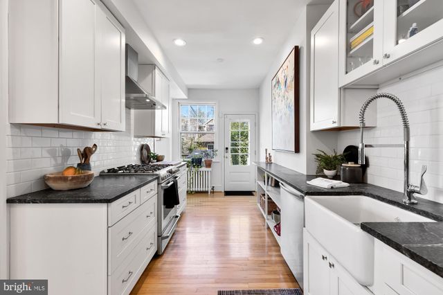 a kitchen with kitchen island granite countertop a sink stainless steel appliances and cabinets