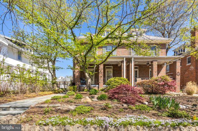 a front view of a house with a tree