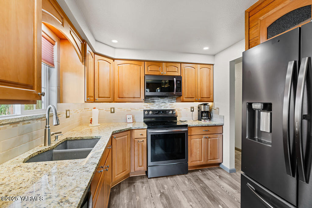 250 Hexon Road Selah, WA 98942 - Photo 22 of 50 a kitchen with granite countertop a sink a counter top space stainless steel appliances cabinets and a window