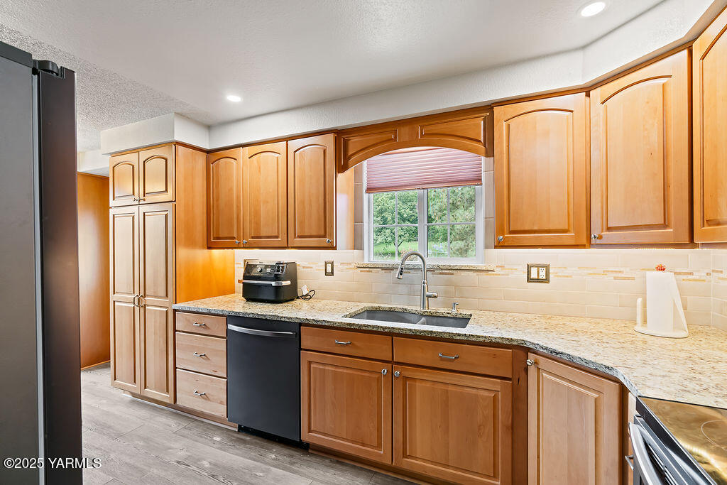 250 Hexon Road Selah, WA 98942 - Photo 23 of 50 a kitchen with stainless steel appliances granite countertop a sink a stove and a refrigerator
