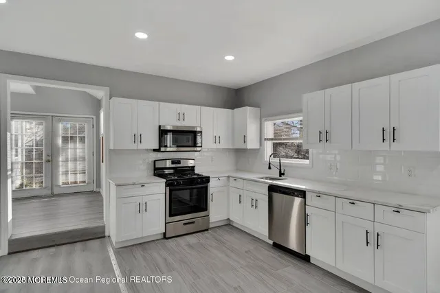 a kitchen with white cabinets stainless steel appliances and sink