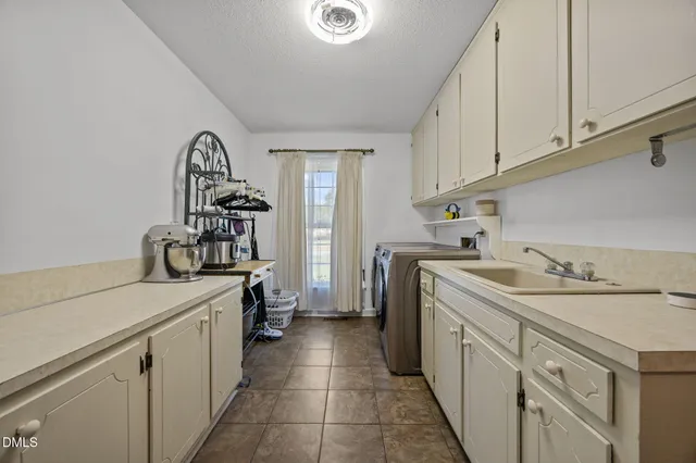 a utility room with sink dryer and washer