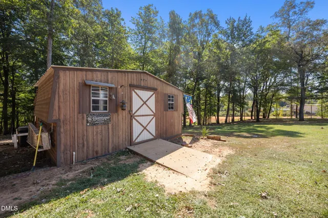 a backyard of a house with trees and outdoor seating