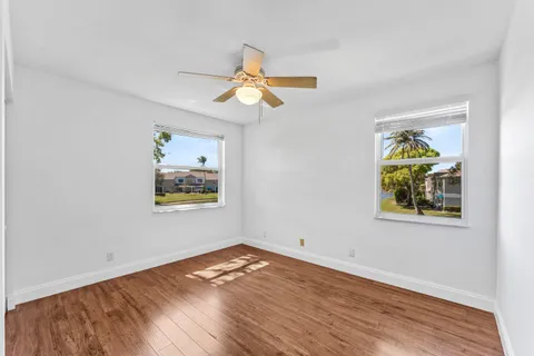 a view of empty room with wooden floor