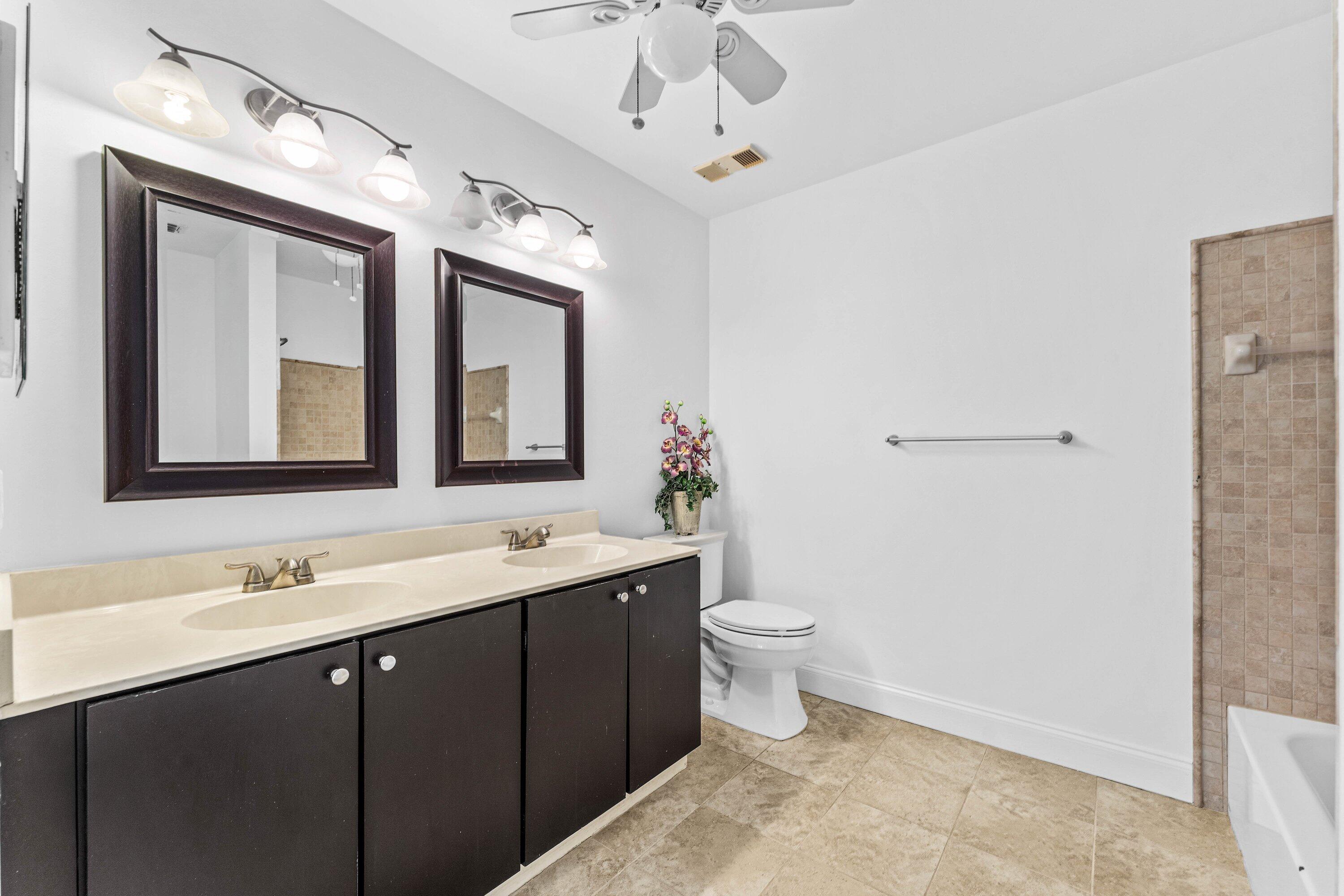 9118 Boca Gardens Parkway, Unit F Boca Raton, FL 33496 - Photo 25 of 56 a bathroom with a toilet sink double vanity and mirror