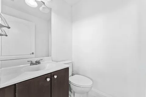 an empty room with wooden floor and ceiling fan