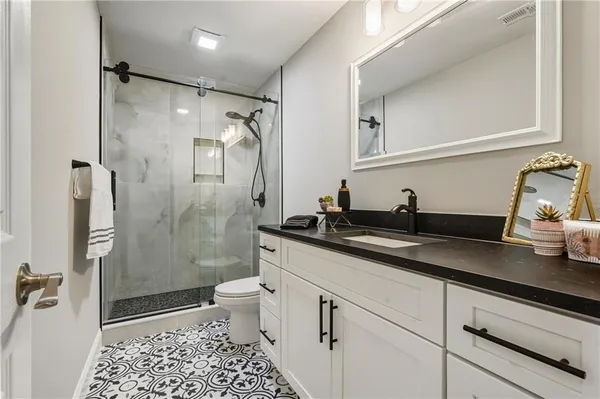 a bathroom with a granite countertop sink toilet and shower