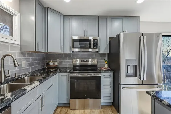 a kitchen with stainless steel appliances a stove a sink and a refrigerator