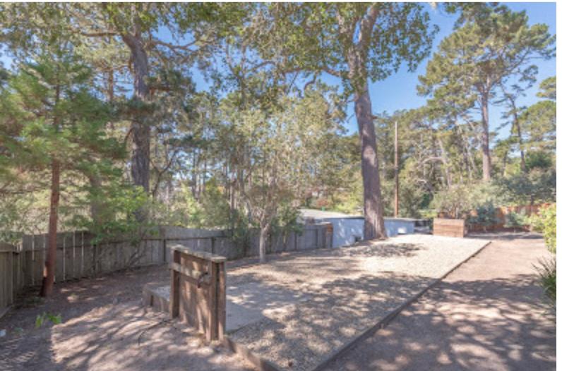 4174 Crest Road Pebble Beach, CA 93953 - Photo 13 of 14 a backyard of a house with large trees and wooden fence