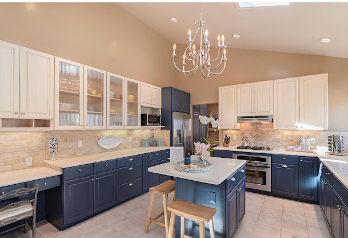 4174 Crest Road Pebble Beach, CA 93953 - Photo 6 of 14 a kitchen with a sink a stove a kitchen island with lots of wooden cabinets and wooden floor