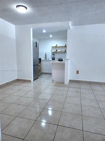 a large white kitchen with a sink and cabinets