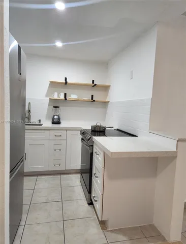 a kitchen with a stove top oven and cabinets