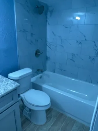 a white toilet and tub sitting next to a bathroom sink