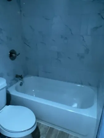 a white bath tub sitting next to a toilet