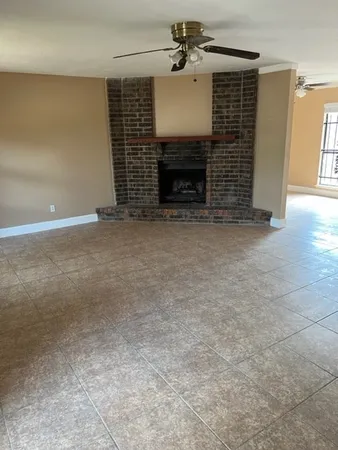 an empty room with fireplace and windows