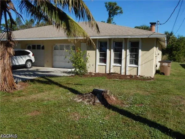 a view of a house with backyard and sitting area