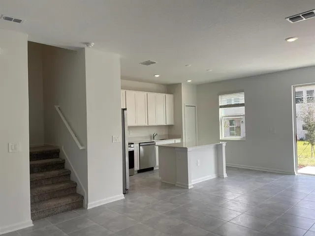 a view of a kitchen with wooden floor and electronic appliances