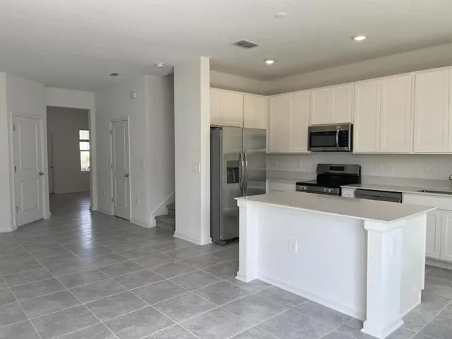 a kitchen with stainless steel appliances a refrigerator a stove a microwave and cabinets