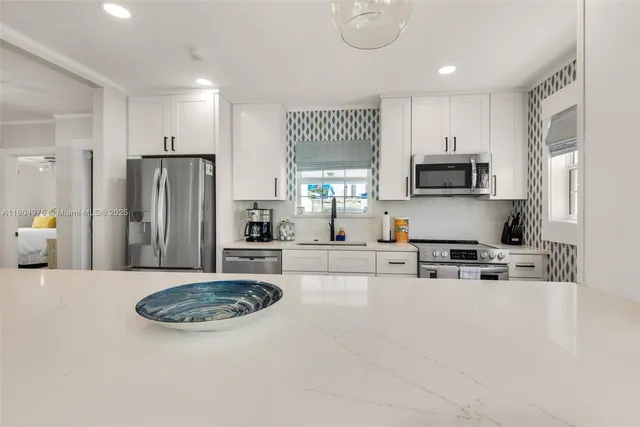 a kitchen with stainless steel appliances a refrigerator sink and cabinets