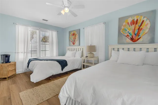 a bedroom with two beds and a painting on the wall