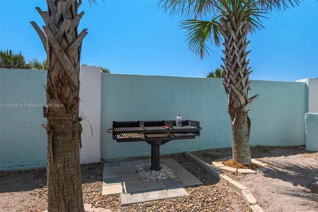 a view of a yard with plants and a bench