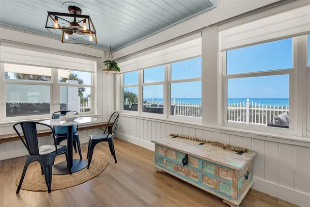 a dining room with furniture a rug and a floor to ceiling window