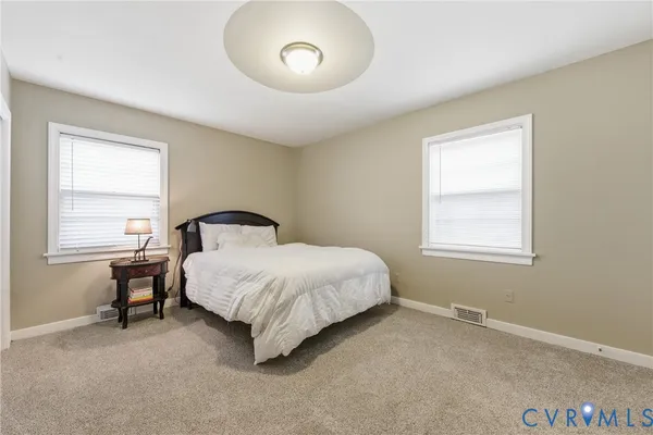 a spacious bedroom with a bed and a window