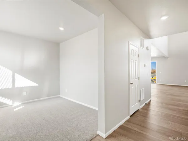 a view of a hallway with wooden floor