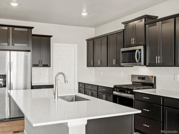 a kitchen with granite countertop a stove and a refrigerator