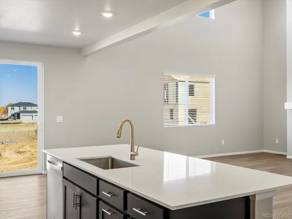 a kitchen with a sink cabinets and wooden floor