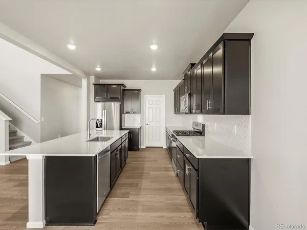 a kitchen with stainless steel appliances a sink stove and cabinets
