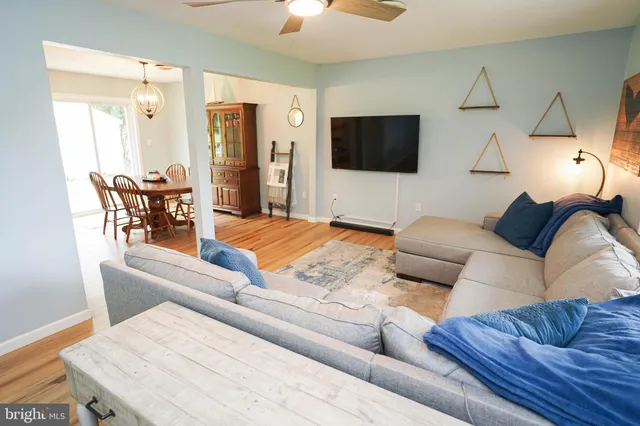 a view of a dining room with furniture a chandelier and wooden floor