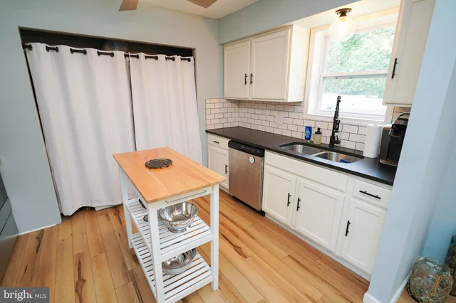 a kitchen with stainless steel appliances a refrigerator a stove a sink and a hard wood floors