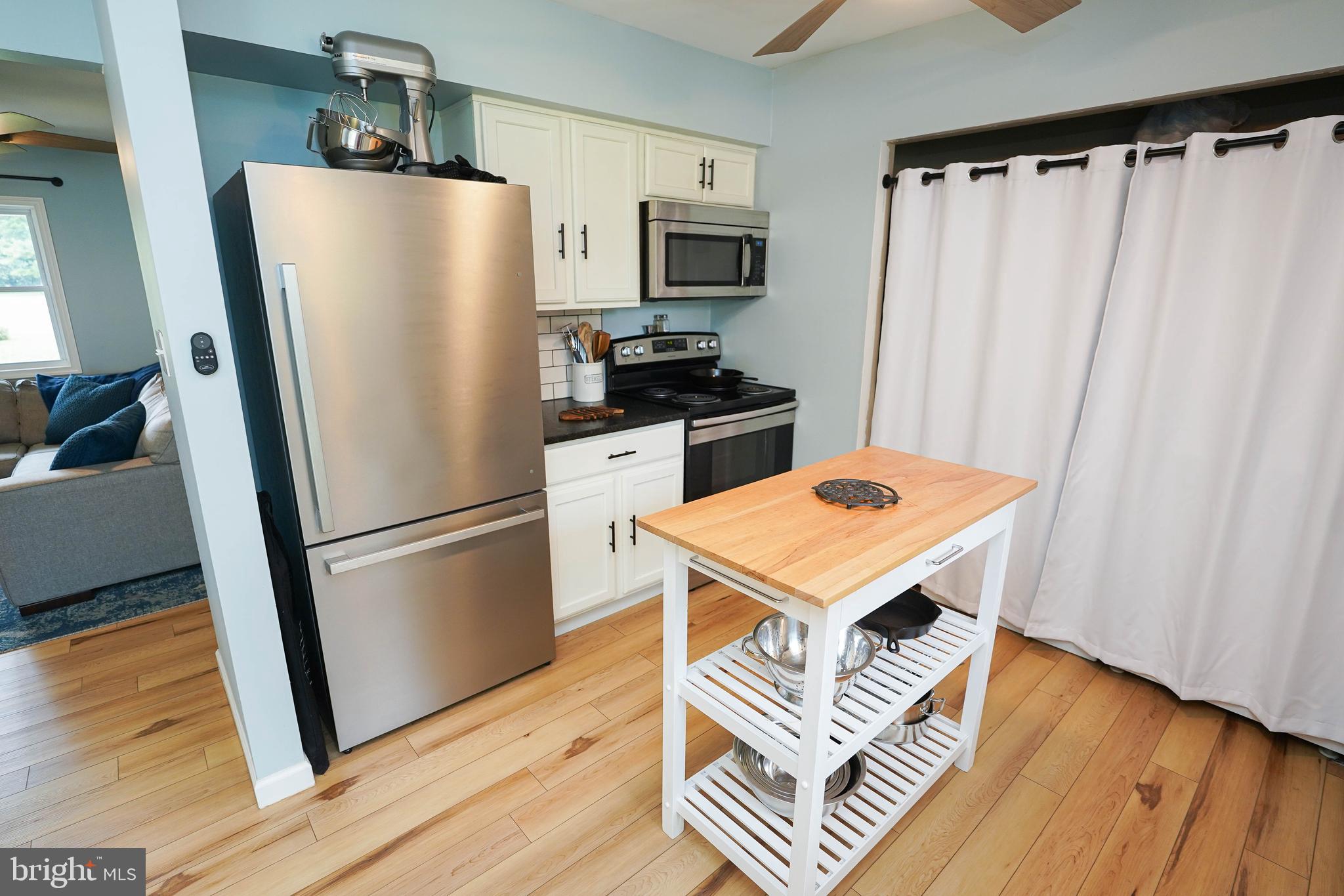 7209 Opal Circle Hebron, MD 21830 - Photo 22 of 41 a kitchen with stainless steel appliances a refrigerator a stove a sink and a hard wood floors