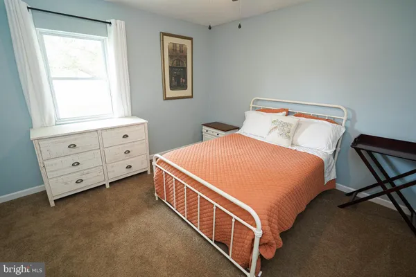 a bedroom with a bed and a chandelier fan