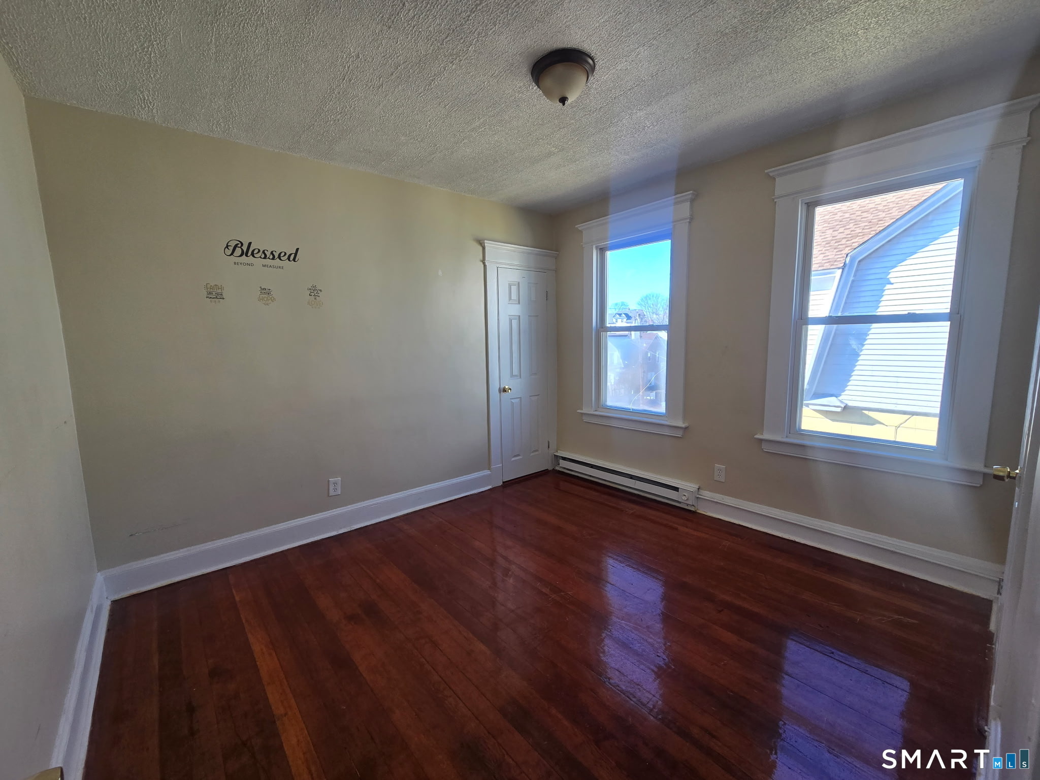 75 Alma Street Waterbury, CT 06705 - Photo 5 of 6 an empty room with wooden floor and windows