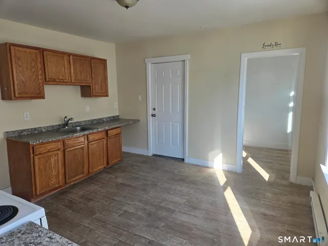 a view of a kitchen with sink cabinets and wooden floor