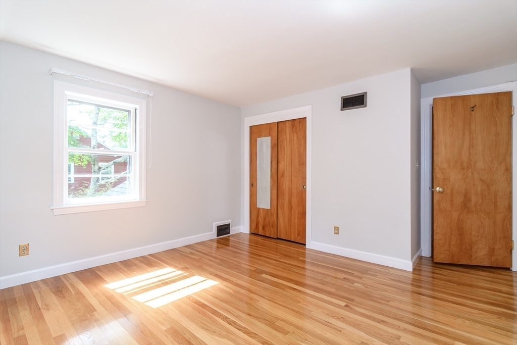 115 Parker Road Wellesley, MA 02482 - Photo 17 of 22 an empty room with wooden floor and windows