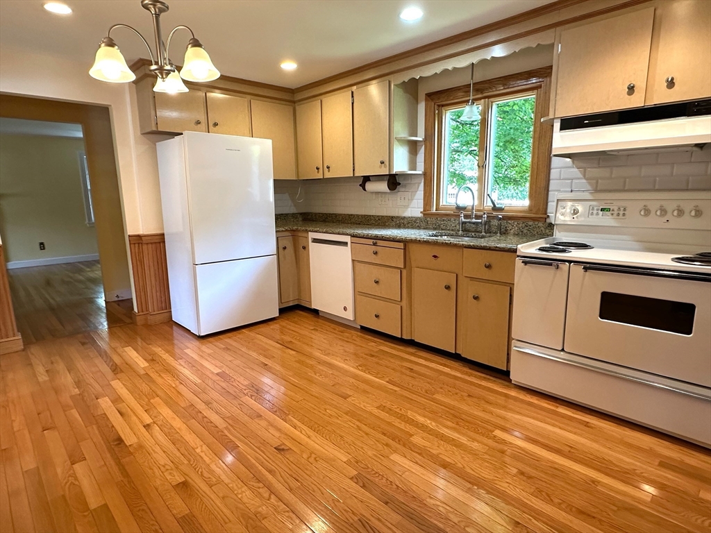 115 Parker Road Wellesley, MA 02482 - Photo 8 of 22 a kitchen with a refrigerator a stove a sink and dishwasher with wooden floor