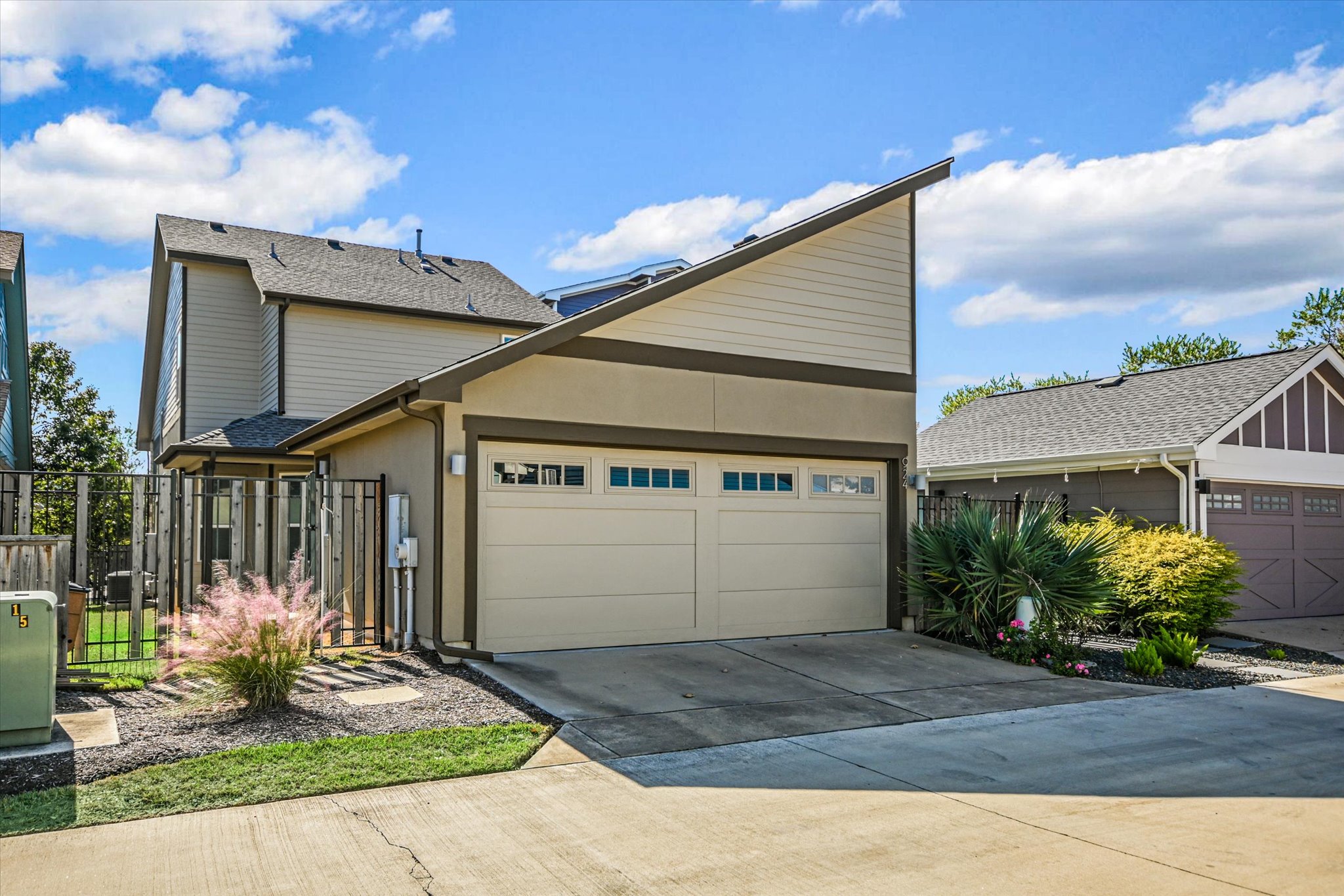 924 Sugaree Avenue Austin, TX 78757 - Photo 9 of 20 View of front facade featuring concrete driveway, a garage, stucco siding, and a gate