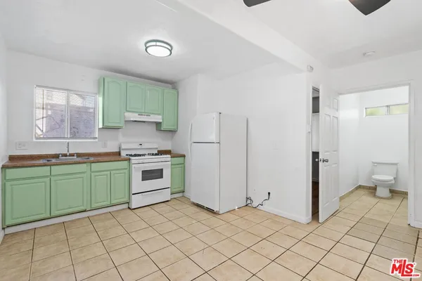 an empty room with wooden floor and fan