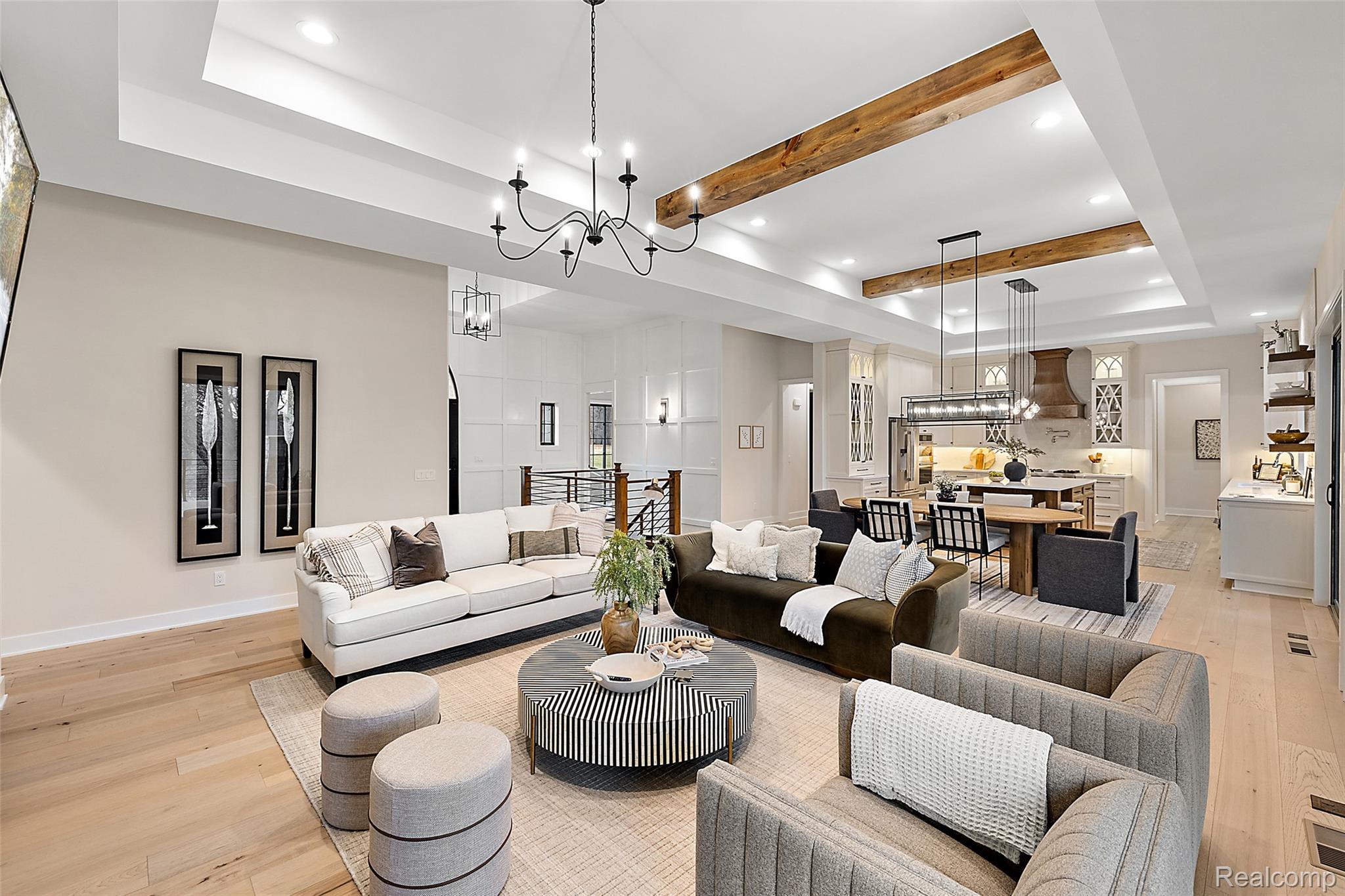 70413 Renata Court Romeo, MI 48065 - Photo 22 of 53 Expansive open-concept living area featuring light wood-finish flooring, a coffered ceiling with exposed wood beams, recessed lighting, and a chandelier