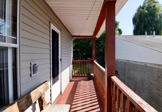a view of balcony with wooden floor and fence