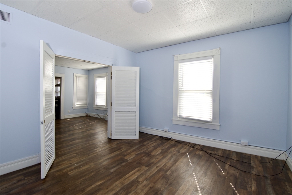425 Taylor Street, Unit 2 Springfield, MA 01105 - Photo 8 of 28 an empty room with wooden floor and windows