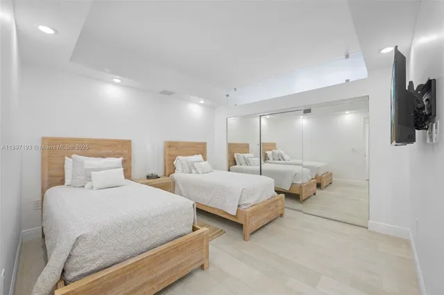 a bedroom with two beds and a flat screen tv