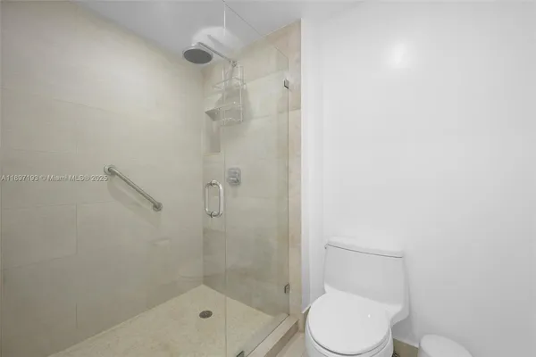 a white toilet next to a bathroom