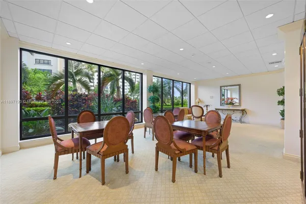 a dining room with furniture a rug and a floor to ceiling window