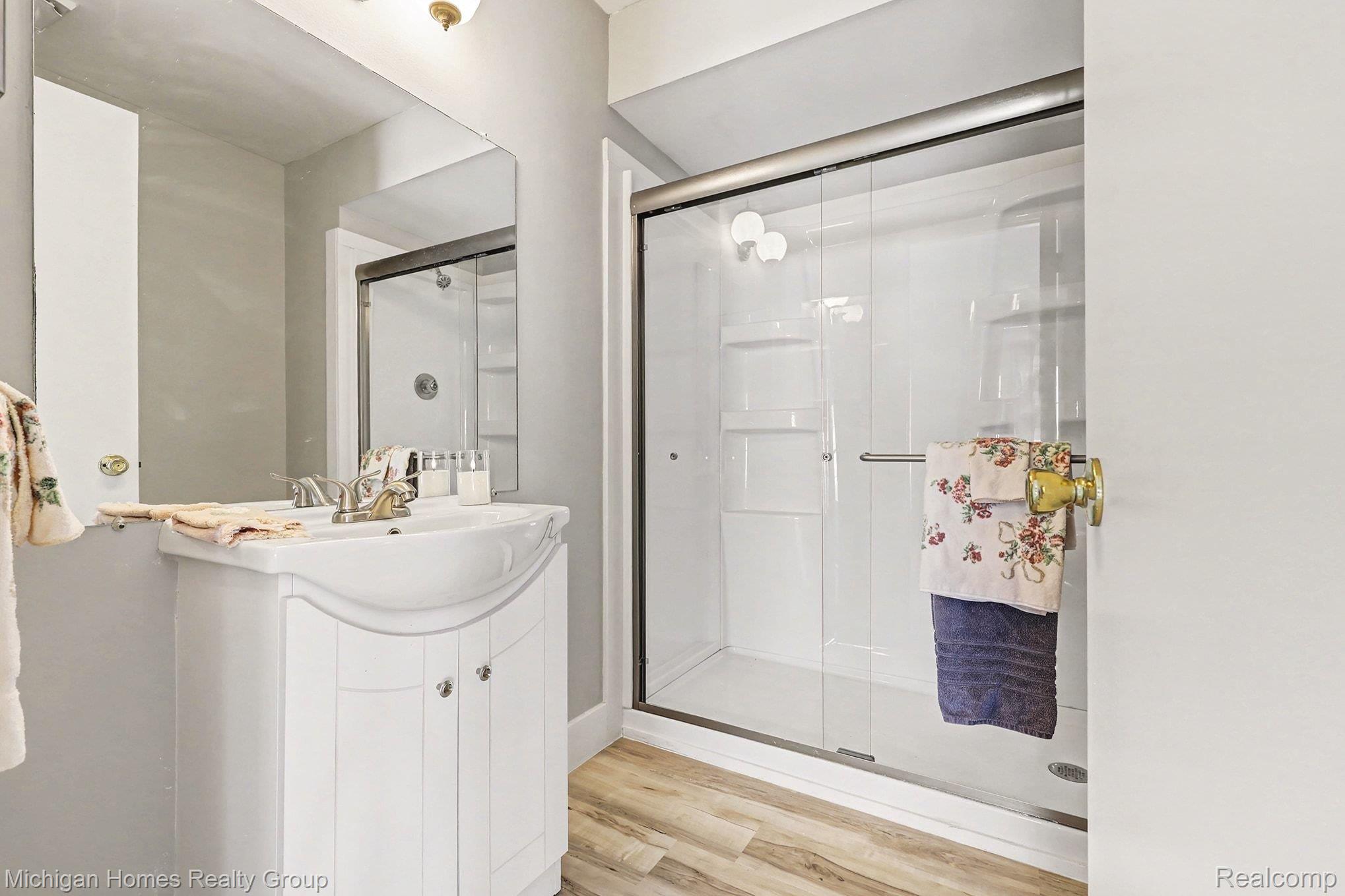1437 Lantern Lane Rochester, MI 48306 - Photo 22 of 31 Full bath with vanity, light wood-type flooring, and a shower stall