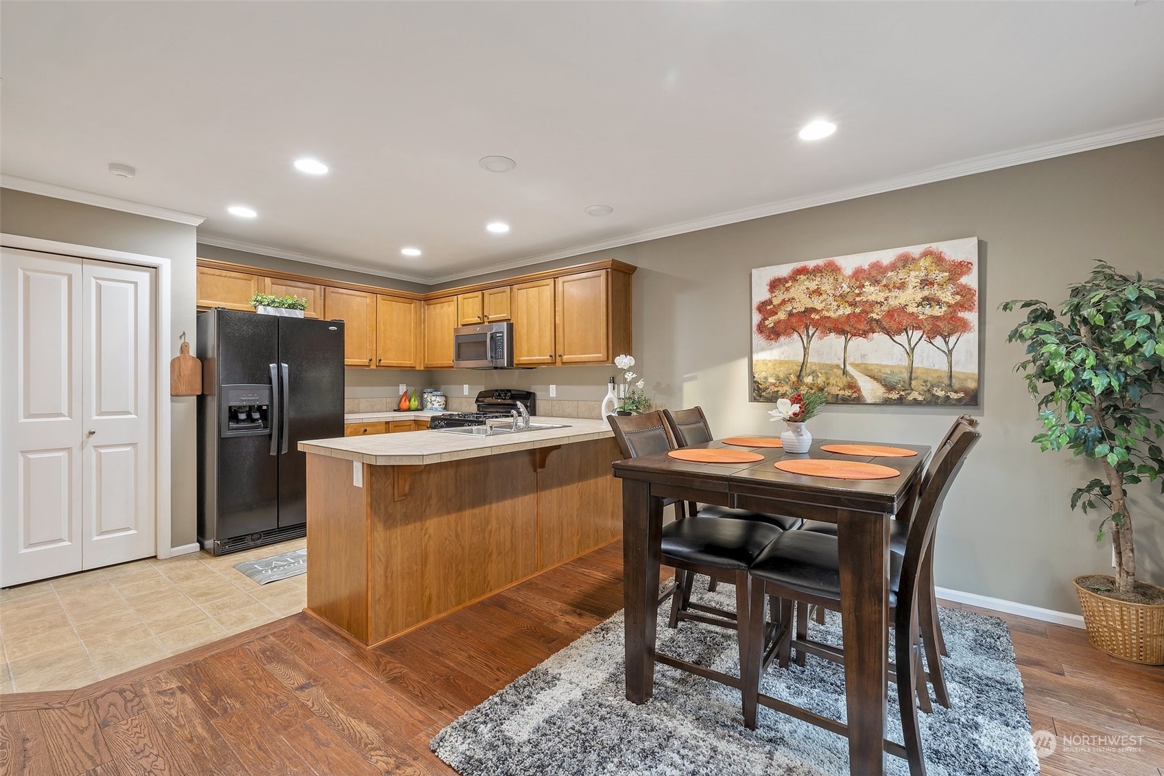 16603 42nd Avenue Southeast Bothell, WA 98012 - Photo 10 of 35 a kitchen with stainless steel appliances granite countertop a refrigerator a stove a sink a dining table and chairs with wooden floor